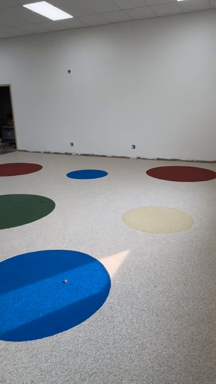 Light speckled rubber flooring with coloured circles at Beyond Play in Barrie